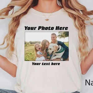 Może przedstawiać: Kremowa koszulka z nadrukiem zdjęcia rodzinnego. Na zdjęciu rodzina z psem, a tekst "Your Photo Here" i "Your text here" jest wydrukowany nad i pod zdjęciem. Słowo "Natural" jest wydrukowane w prawym dolnym rogu.