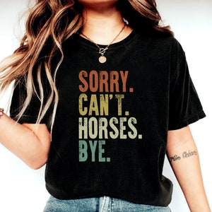 May include: A black t-shirt with a vintage-style graphic that reads "Sorry. Can't. Horses. Bye."