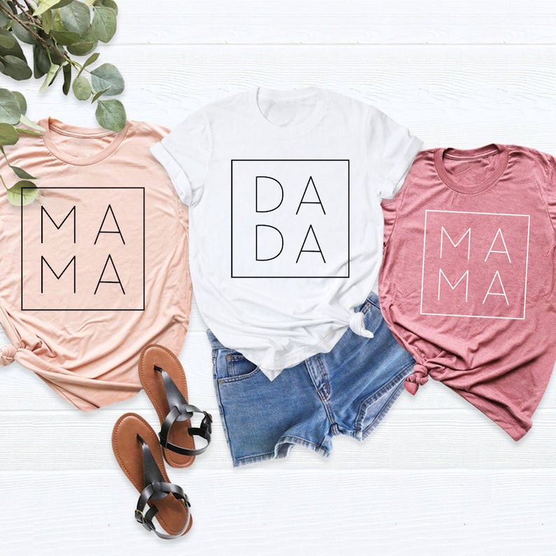 May include: Three t-shirts with the words "Mama", "Dada", and "Mama" printed on them. The shirts are in pink, white, and light pink.