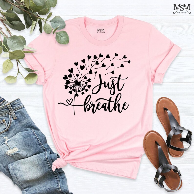 May include: Pink t-shirt with a black dandelion design and the text "Just breathe".