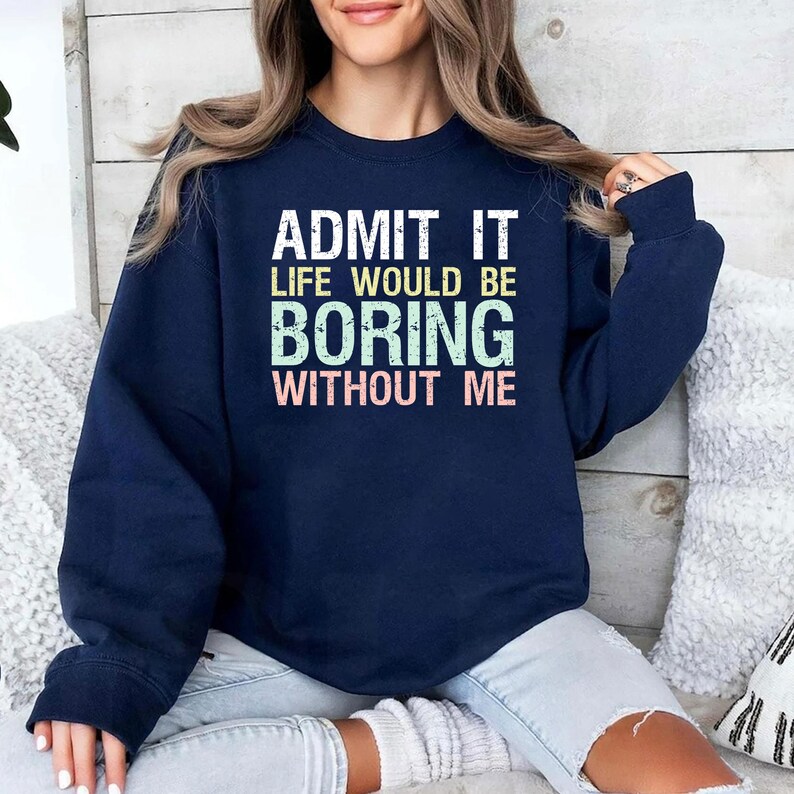 May include: Navy blue sweatshirt with the text "ADMIT IT LIFE WOULD BE BORING WITHOUT ME" in white, green, and pink. The sweatshirt is a long-sleeved, crew neck style.