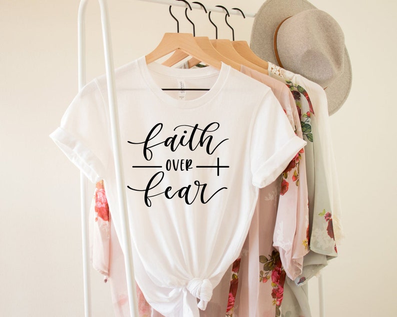 May include: White t-shirt with the text "faith over fear" written in black cursive script.