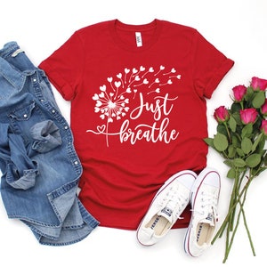 May include: Red t-shirt with a white dandelion design and the text "Just breathe".