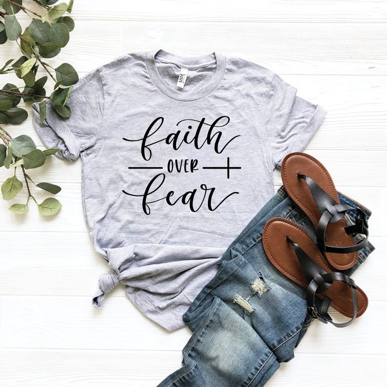 May include: A gray t-shirt with the text "faith over fear" in black cursive lettering.