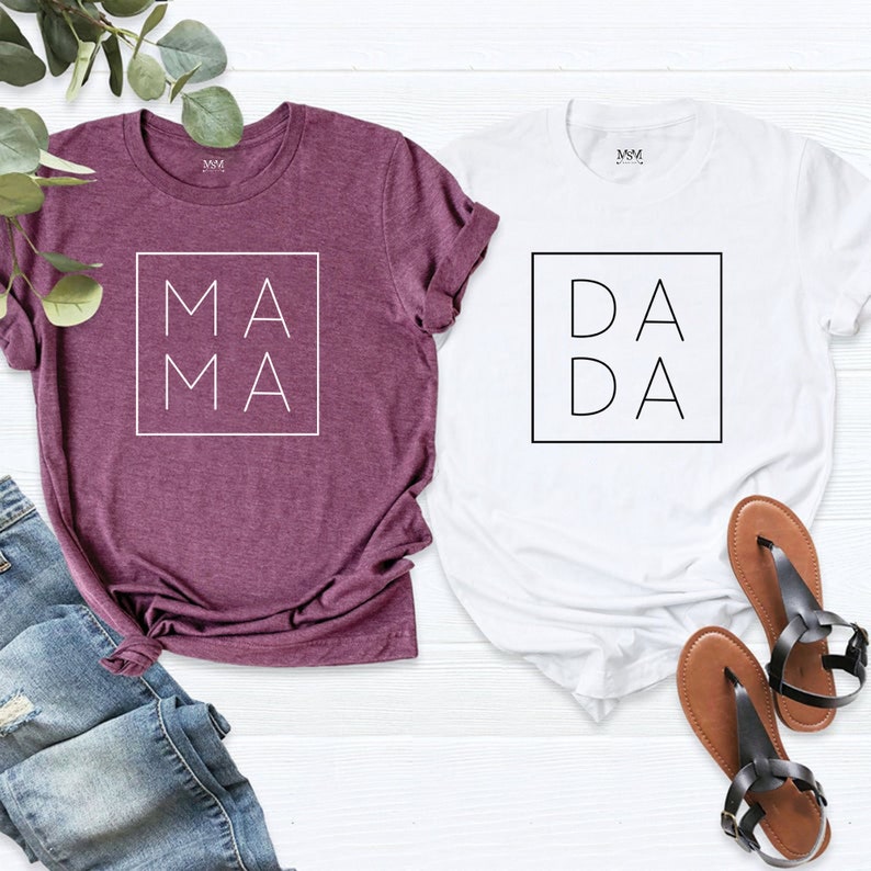 May include: Two t-shirts, one maroon and one white, with the words "MAMA" and "DADA" printed in a square on the front.