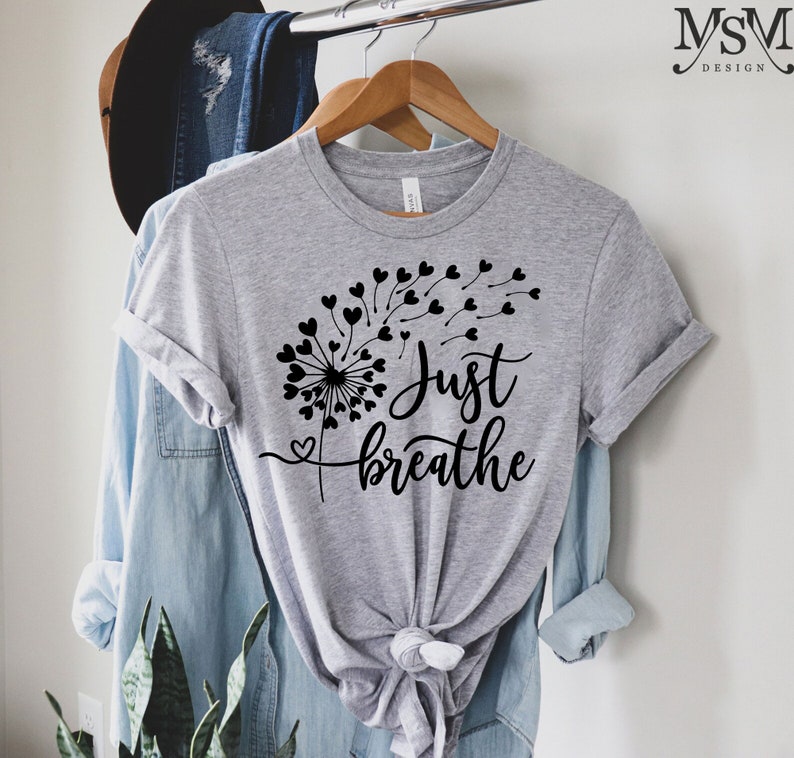 May include: Gray t-shirt with a black dandelion design and the text "Just breathe".