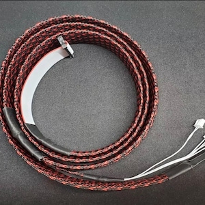 May include: Coiled black, red, and white braided cable with multiple white connectors. The cable is wrapped in a circular pattern. The ends of the cable are covered in black heat shrink tubing.