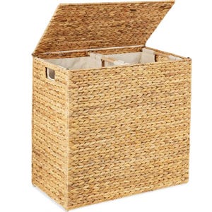 May include: A natural woven laundry hamper with a lid, divided into two compartments. The hamper is made of woven seagrass and has a natural finish.