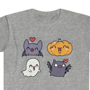 May include: A gray t-shirt with a cute cartoon design featuring a bat, ghost, pumpkin, and cat. Each character has a heart above their head.