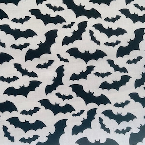 K&ouml;nnte beinhalten: Ein wei&szlig;er Stoff mit einem sich wiederholenden Muster aus schwarzen Fledermaus-Silhouetten.