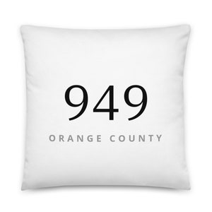 May include: White throw pillow with black text that reads "949 ORANGE COUNTY".