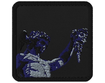 May include: Embroidered patch featuring a classical statue in shades of blue and white against a black background. The patch has a square shape with rounded corners, and the statue is holding an object aloft.