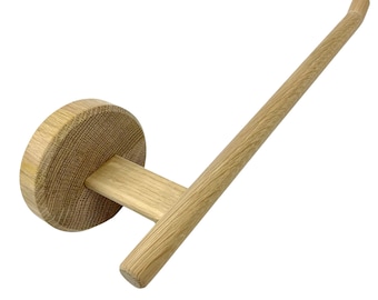 Puede incluir: Un toallero de madera con una base redonda y un brazo curvo. El toallero está hecho de madera natural y tiene un acabado marrón claro.
