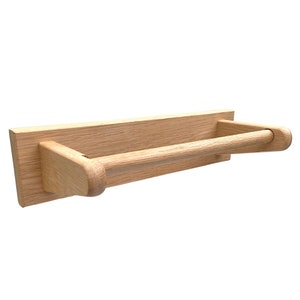 Puede incluir: Un porta rollo de papel de cocina de madera con un acabado natural. El soporte tiene una barra redondeada para sujetar el rollo de papel de cocina y est&aacute; montado en la pared.