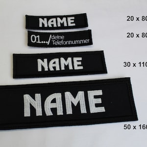 Könnte beinhalten: Vier schwarze Stoff-Patches mit weiß gesticktem Text "NAME" in verschiedenen Größen: 5 x 5 cm, 5 x 5 cm, 7,6 x 11 cm und 10 x 16 cm.