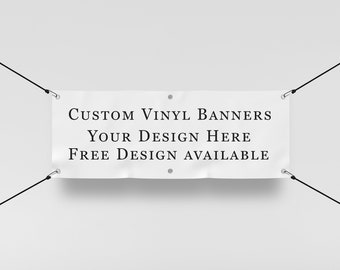 May include: White vinyl banner with black text that reads "Custom Vinyl Banners Your Design Here Free Design Available". The banner is hanging from two black strings.