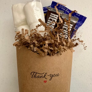May include: A brown paper bag filled with white marshmallows and chocolate bars, with a "Thank you" sticker on the front.