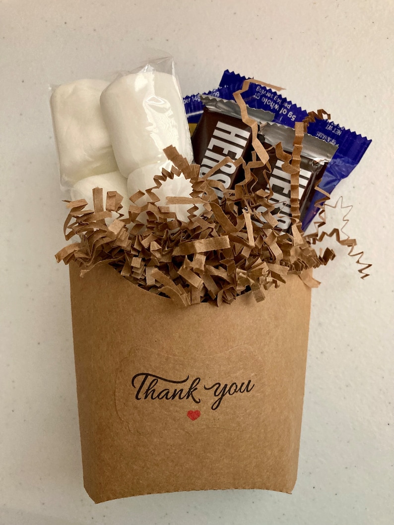May include: A brown paper bag filled with white marshmallows and chocolate bars, with a "Thank you" sticker on the front.