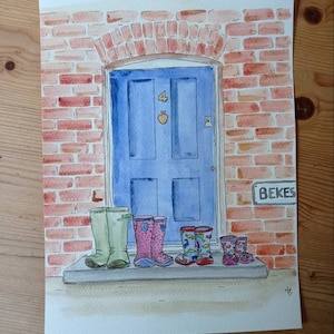 Puede incluir: Una pintura de acuarela de una puerta azul con el número 4 y una manzana encima. La puerta está en un edificio de ladrillo con un letrero que dice "BEKES". Hay cinco pares de botas de lluvia coloridas alineadas en el escalón frente a la puerta.