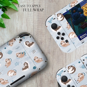 May include: A full wrap skin for a Nintendo Switch console and controllers featuring a light blue background with a repeating pattern of sloths in space. The sloths are wearing pajamas and have the words "nope" and "I need more space" written on them. The controllers have a rocket ship design on the back.
