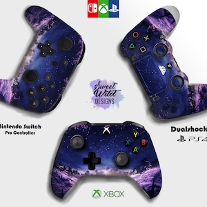 Peut inclure: Trois manettes de jeu différentes avec un design de ciel étoilé. Les manettes sont pour la Nintendo Switch, la Playstation 4 et la Xbox. Le design présente un ciel violet et bleu avec des étoiles et une silhouette d'arbres en arrière-plan.