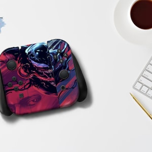 Może przedstawiać: Czarny kontroler Nintendo Switch Joy-Con z niestandardową skórką, która prezentuje abstrakcyjny wzór w kolorze czerwonym i niebieskim z czarno-białym obrazem Venomma z komiksów Marvela.