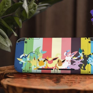 Puede incluir: Una piel colorida para la consola Nintendo Switch con un fondo a rayas y varios personajes de Pokémon, incluyendo a Eevee y sus evoluciones. La piel está diseñada para adaptarse a la consola y los mandos de Nintendo Switch.