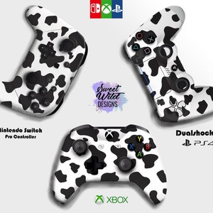 Könnte beinhalten: Drei verschiedene Videospiel-Controller mit einem schwarz-weißen Kuhmuster. Die Controller sind für Nintendo Switch, Xbox und Playstation 4.