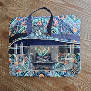 May include: A patterned tote bag with a navy blue handle and zip. The bag is open, revealing clear plastic containers. The bag's design includes paisley and floral patterns in shades of blue, orange, and green.