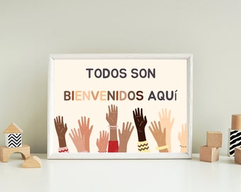 May include: A white framed print with the text "TODOS SON BIENVENIDOS AQUÍ" in Spanish. The print features a colorful illustration of raised hands of different skin tones.