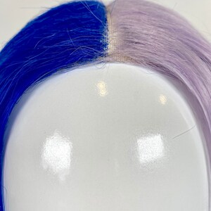 May include: A half blue and half lavender wig on a white mannequin head.