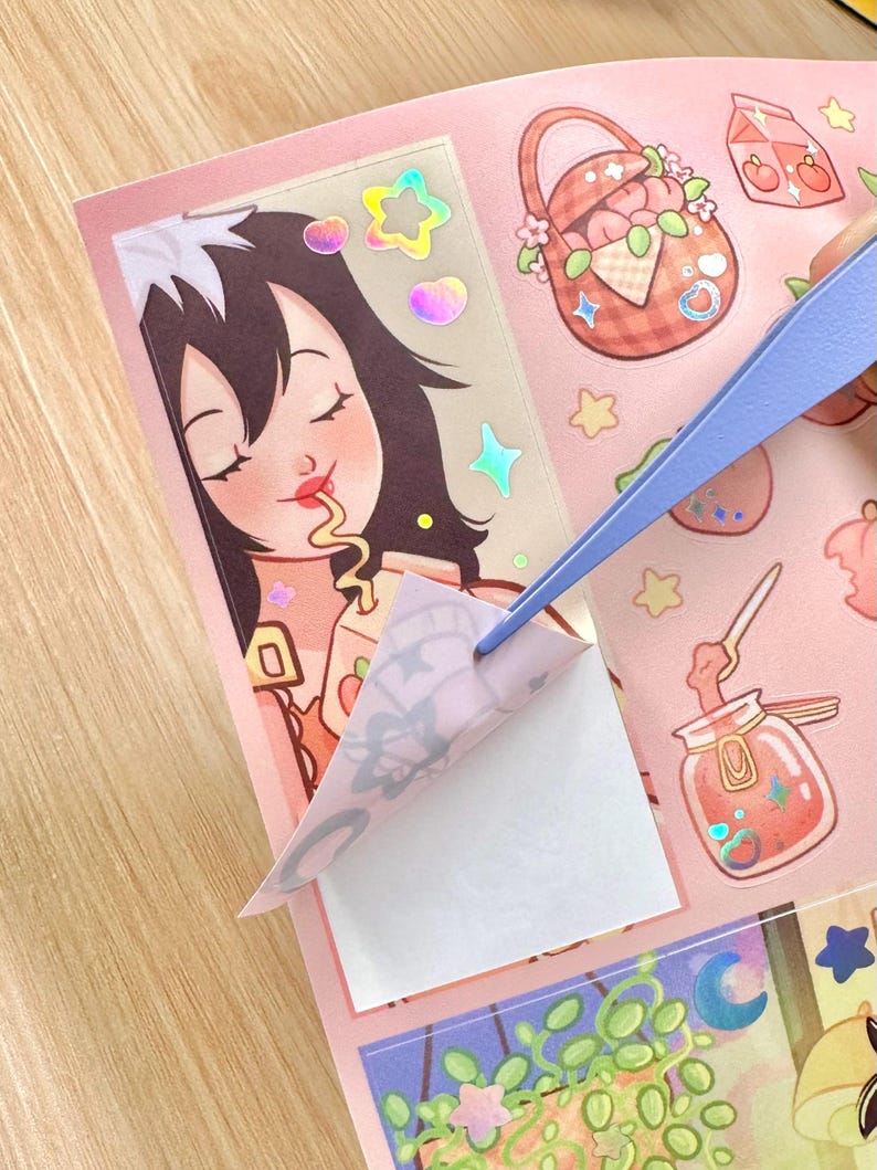 May include: A sheet of pink stickers with various illustrations, including a girl eating, a picnic basket, and a jar of jam. A pair of blue tweezers is peeling off a sticker. The stickers have a holographic effect.