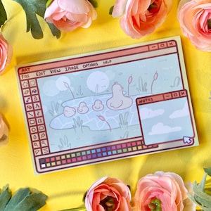 May include: A yellow and brown illustrated notepad with a computer screen design. The screen shows a cartoon image of a pond with four chicks and a blue sky with clouds. The notepad has a toolbar with the words "Art", "File", "Edit", "View", "Image", "Options", and "Help".