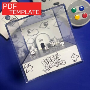 Puede incluir: Una vitrina de plástico transparente con un diorama en blanco y negro de Kirby's Dream Land. El diorama incluye personajes pixelados, nubes y el texto "Kirby's Dream Land". La esquina superior izquierda tiene un rectángulo rojo con el texto "PDF TEMPLATE".
