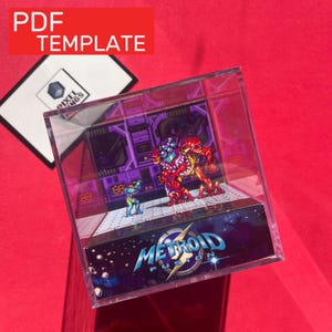 Könnte beinhalten: Ein klarer Acrylblock mit einem Metroid Fusion Diorama. Das Diorama zeigt pixelige Charaktere in einer futuristischen Umgebung. Der Sockel des Blocks zeigt das Logo des Spiels. Eine weiße Karte mit "PDF TEMPLATE" befindet sich oben links.