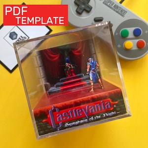 May include: A clear acrylic display case featuring a miniature diorama of a scene from the video game "Castlevania: Symphony of the Night." The diorama includes two pixelated figures, a red carpet, and a red curtain backdrop. The case has the game's logo on the front.