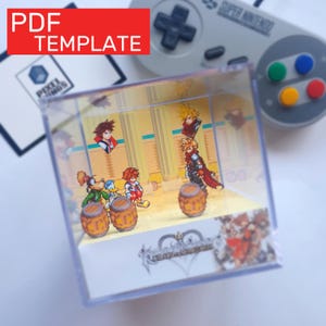 Puede incluir: Un cubo de exhibición de acrílico transparente con una escena de videojuego, con personajes y barriles. El cubo tiene el texto "PDF TEMPLATE" en un cuadro rojo. Un mando de Super Nintendo está en el fondo.