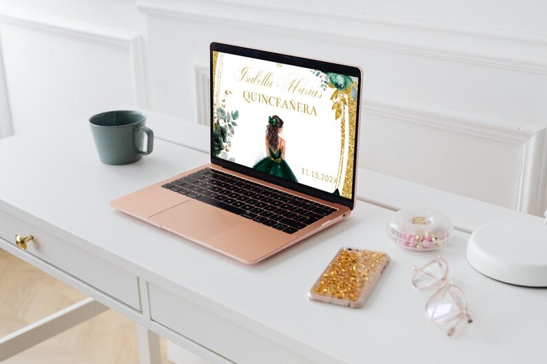 May include: A laptop computer displaying a digital invitation for a Quincea&ntilde;era. The invitation features a green and gold design with a floral border and the text "Isabella Maria Quincea&ntilde;era 11.13.2023".