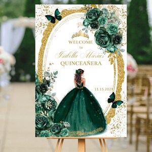 May include: Welcome to Isabella Maria's Quinceanera sign with a gold glitter background and a green floral design. A silhouette of a woman in a green gown is featured in the center of the sign. The date 11.15.2022 is printed in the bottom right corner.