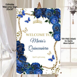 May include: A white welcome sign with gold glitter and blue flowers. The text on the sign reads "Welcome to Maria's Quincea&ntilde;era April 15th 2023".