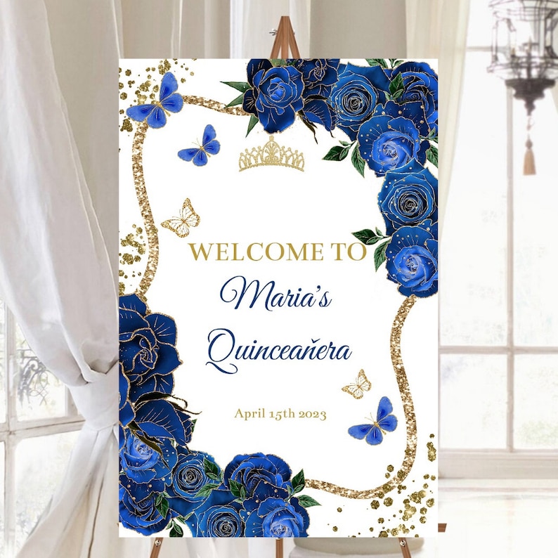 May include: Welcome to Maria's Quincea&ntilde;era sign with blue roses, gold glitter, and butterflies. The date April 15th 2023 is printed below the text.