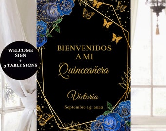 May include: A black welcome sign with gold lettering and blue floral accents. The sign reads "Bienvenidos a mi Quinceañera Victoria Septiembre 15, 2022".