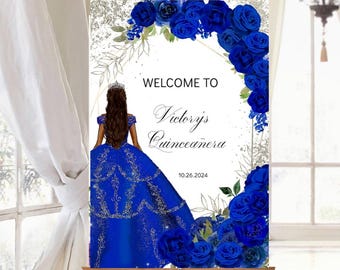 May include: Welcome to Victoria's Quinceañera sign with a blue and silver glitter background. The sign features a silhouette of a young woman in a blue gown with a crown and a floral border of blue roses.