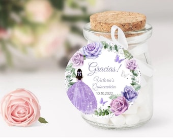 May include: Round favor tag with a purple and white floral design, a girl in a purple dress, and the text "Gracias! Victoria's Quinceañera 10.10.2022"