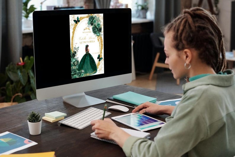 May include: A computer screen displaying a digital invitation with a green and gold design. The invitation features a woman in a green gown with a butterfly on her shoulder. The text on the invitation reads "Welcome to the Quincea&ntilde;era".