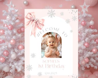 May include: A pink welcome sign for a first birthday party. The sign features a photo of a baby, a pink bow, and the text "WELCOME TO" above the photo. Below the photo, the sign reads "SOPHIA'S 1st Birthday" and the date "12.10.2025".