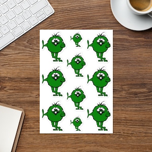 May include: A sheet of stickers featuring a cartoon green monster with a mischievous expression giving the middle finger. The stickers are arranged in a grid pattern on a white background.