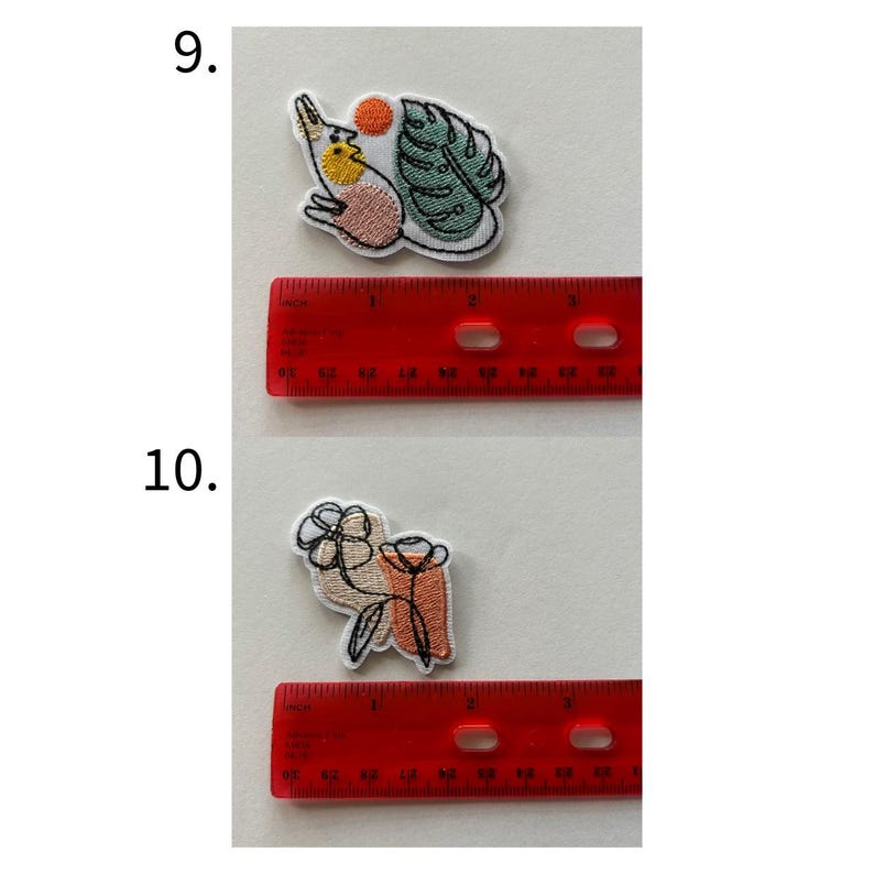 May include: Two embroidered patches. The top patch features a bird with a yellow chest, a red sun, and a green leaf. The bottom patch shows a flower and a vase in beige, orange, and black. Each patch is approximately 1 inch in size.