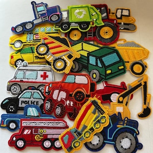 May include: A collection of colorful embroidered patches featuring various vehicles, including a fire truck, ambulance, police car, and dump truck. The patches are in shades of red, blue, green, and yellow, with detailed stitching and designs. The patches are ideal for decorating clothing or accessories.