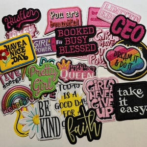 May include: A collection of embroidered patches with various motivational phrases and designs. The patches feature text like "Hustler," "You are beautiful," "CEO," and "Dream it & Do it." Colors include pink, black, yellow, and white.